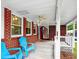 Relaxing porch with ceiling fan, cozy blue chairs, brick foundation, and ample outdoor space at 104 Bryant St, Saint George, SC 29477