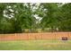 Inviting backyard with wooden fence, gate, fire pit, and view of the wooded area at 107 Belgian Ct, Summerville, SC 29486