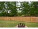 Green backyard with a wooden fence and fire pit at 107 Belgian Ct, Summerville, SC 29486