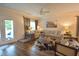 Bright living room with large sectional couch, side chairs, fireplace, TV, ceiling fan and doors to outside at 107 Belgian Ct, Summerville, SC 29486