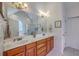 Bright bathroom features double sinks, wood cabinets, large mirror, and access to bathtub and toilet area at 1207 Rivers Reach Dr, Wando, SC 29492
