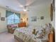 Bedroom features neutral walls, patterned bedding, a ceiling fan, and natural light at 1207 Rivers Reach Dr, Wando, SC 29492