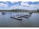 View of boat dock extending into the waterway, surrounded by beautiful residential homes and greenery at 1207 Rivers Reach Dr, Wando, SC 29492