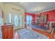 Elegant dining room featuring a wood table, display cabinet, hardwood floors, and a striking red accent wall at 1207 Rivers Reach Dr, Wando, SC 29492