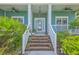 Welcoming front entrance with green siding, brick stairs, and surrounded by beautiful plants and trees at 1207 Rivers Reach Dr, Wando, SC 29492