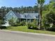 Charming home featuring a manicured lawn, lush landscaping and inviting front porch at 1207 Rivers Reach Dr, Wando, SC 29492