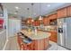 Kitchen features an island with bar seating, stainless steel appliances, and custom wood cabinetry at 1207 Rivers Reach Dr, Wando, SC 29492