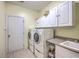 Well-equipped laundry room with white cabinetry, granite countertop, and modern washer and dryer at 1207 Rivers Reach Dr, Wando, SC 29492