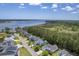Aerial view showcasing a neighborhood near the waterfront and adjacent to a lush, wooded area with beautiful landscaping at 1207 Rivers Reach Dr, Wando, SC 29492