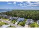 Aerial view of a peaceful neighborhood with mature trees, and a glimpse of the Intracoastal Waterway in the background at 1207 Rivers Reach Dr, Wando, SC 29492