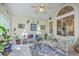 Bright sunroom with tile flooring and white wicker furniture under a high ceiling and ample windows at 1207 Rivers Reach Dr, Wando, SC 29492
