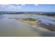 Aerial view of the waterway and coastal landscape with blue skies and marshland in the background at 1207 Rivers Reach Dr, Wando, SC 29492