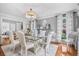 Elegant dining room with glass top table, chandelier, and natural light, perfect for entertaining at 122 Hidden Fawn Cir, Goose Creek, SC 29445