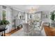 Bright dining room with glass table, gray sideboard, hardwood floors and stylish chandelier at 122 Hidden Fawn Cir, Goose Creek, SC 29445