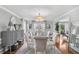 Elegant dining room with glass top table, chandelier, and natural light, perfect for entertaining guests at 122 Hidden Fawn Cir, Goose Creek, SC 29445