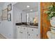 A well-lit wet bar features white cabinets, a black countertop, mirror backsplash, and decorative molding at 122 Hidden Fawn Cir, Goose Creek, SC 29445