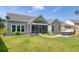 Backyard view showcasing the screened-in porch and a hot tub area with lush, green landscaping at 1245 Hammrick Ln, Johns Island, SC 29455