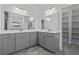 Bright bathroom featuring double sinks, large mirrors, gray cabinets, and tiled flooring at 1245 Hammrick Ln, Johns Island, SC 29455