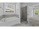 Bathroom with separate tub and shower, gray tiling, and natural lighting at 1245 Hammrick Ln, Johns Island, SC 29455