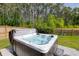 Backyard with a hot tub, privacy fence, grass lawn, and perimeter of dense trees at 1245 Hammrick Ln, Johns Island, SC 29455