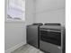 Well-lit laundry room with stainless steel washer and dryer and added wire rack shelving at 1245 Hammrick Ln, Johns Island, SC 29455