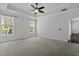 Expansive main bedroom with carpet flooring, tray ceiling, fan, and two windows at 1245 Hammrick Ln, Johns Island, SC 29455