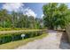 Community pond and walking path bordered by mature trees on a sunny day at 1245 Hammrick Ln, Johns Island, SC 29455