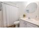Well-lit bathroom featuring a white vanity, round mirror, shower with white curtain, and neutral wall color at 126 W 2Nd St, Folly Beach, SC 29439