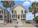 Charming two-story beach home with double garages, central stairway, and palm trees at 126 W 2Nd St, Folly Beach, SC 29439