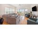 Bright living room featuring a large gray sofa, hardwood floors, and a balcony with seating at 126 W 2Nd St, Folly Beach, SC 29439