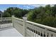 A balcony with white railings overlooks a lush green landscape, offering a serene outdoor space at 133 Wando Reach Rd, Wando, SC 29492