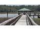 Wooden dock leads to a covered pier on the water, offering scenic views and access to boating at 133 Wando Reach Rd, Wando, SC 29492