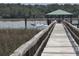 Beautiful waterfront view featuring a long wooden dock, gazebo and boat at 133 Wando Reach Rd, Wando, SC 29492