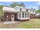Spacious backyard featuring white and red brick house, with a patio area and mature trees at 1534 Salisbury St, Charleston, SC 29407