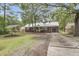 Charming brick home with a metal roof, well-maintained landscaping, and long concrete driveway at 1534 Salisbury St, Charleston, SC 29407
