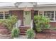 Inviting home entrance with brick steps, white railing, green door, and vibrant landscaping at 1534 Salisbury St, Charleston, SC 29407