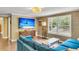 Living room with a mounted TV, blue sofa, wood floors, and a view through the window at 1534 Salisbury St, Charleston, SC 29407