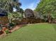 Lush green backyard featuring a well-maintained lawn, trees, and plants along the fence at 16 Charlyn Dr, Charleston, SC 29407