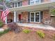 Charming front porch with rocking swing and patriotic flag; brick home at 16 Charlyn Dr, Charleston, SC 29407