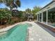 Private backyard pool area with ample seating, lush landscaping, and a sunroom at 16 Charlyn Dr, Charleston, SC 29407