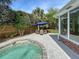 Beautiful pool area surrounded by lush greenery and a charming outdoor dining space at 16 Charlyn Dr, Charleston, SC 29407