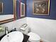 Elegant powder room with stylish artwork, dark blue walls, and classic fixtures at 16 Charlyn Dr, Charleston, SC 29407