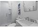 Bright bathroom with white tiled shower, vanity, and decorative wall art at 177 Spring St, Charleston, SC 29403