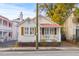 Quaint home featuring a red roof, shuttered windows, and inviting front porch amidst vibrant foliage at 177 Spring St, Charleston, SC 29403