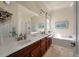 Bright bathroom featuring a dual sink vanity, large mirror, soaking tub, and separate glass-enclosed shower at 1781 Tennyson # 6, Mount Pleasant, SC 29466