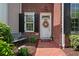 Inviting front door with wreath, brick facade, black shutters, and a cozy bench at 1781 Tennyson # 6, Mount Pleasant, SC 29466