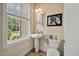 Charming powder room with a pedestal sink, framed horse print, and window with tree view at 1781 Tennyson # 6, Mount Pleasant, SC 29466