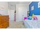 Bright bedroom with blue accent wall, complemented by neutral tones and a cheerful arrangement of toys at 179 Darby Meadow Ln, Ridgeville, SC 29472