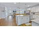 Bright, open-concept kitchen and living space with white cabinets, island seating, and hardwood flooring at 179 Darby Meadow Ln, Ridgeville, SC 29472