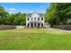 Charming two-story white home with a well-manicured lawn and inviting front porch at 1872 Rifle Range Rd, Mount Pleasant, SC 29464